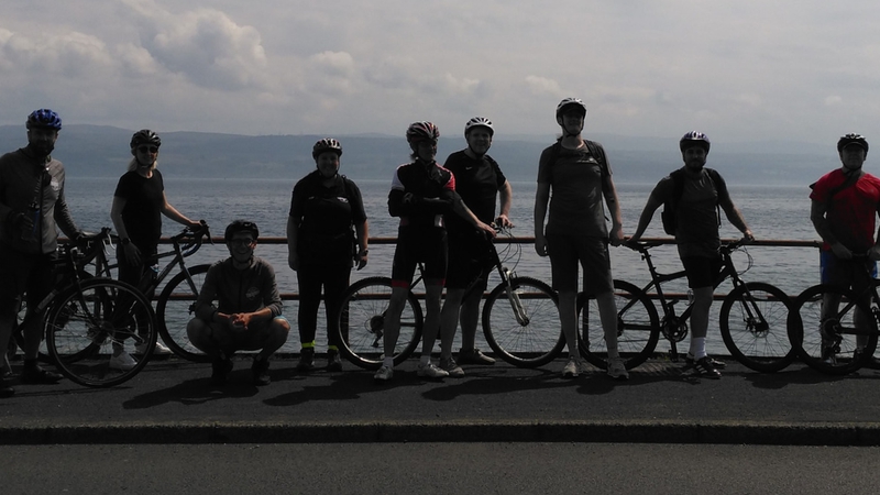 picture for projectStory: Cyclists standing by a beach front with their bikes.