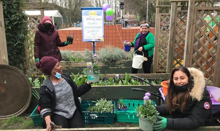 Participants plant flowers as part of Welcome Women project