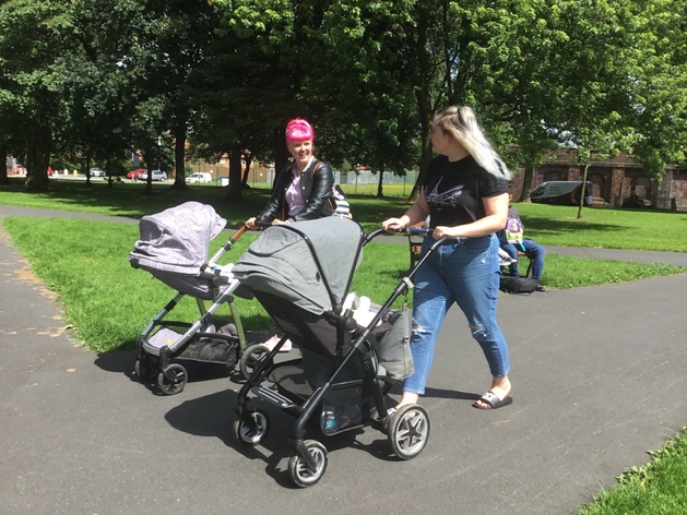 picture for projectStory: Two people walk with push chairs in a park