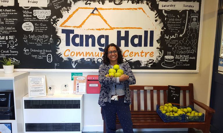 Woman stands in front of project poster with food